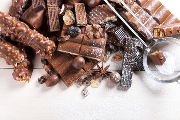 Chocolate sweets with powder on wooden background