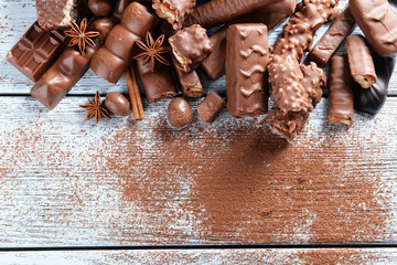 Chocolate sweets with powder on wooden background