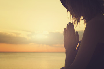 Young woman practicing yoga on the beach.
