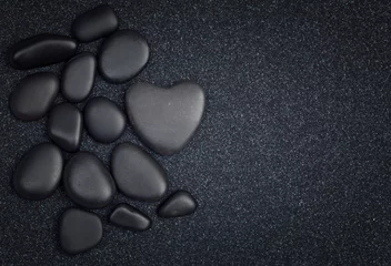 Gartenposter Steine​ im Sand Schwarze Steine mit schwarzem Zen herzförmigem Felsen auf Kornsand