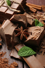 Variety of chocolate pieces, coffee grains and cocoa powder on wooden background