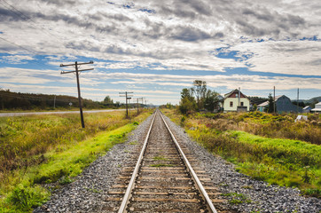 Fototapeta na wymiar Straight Stretch of Railroad and Cloudy Sky