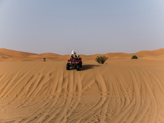 Fototapeta na wymiar an arabic guy on a quad in the desert