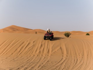 Fototapeta na wymiar an arabic guy on a quad in the desert