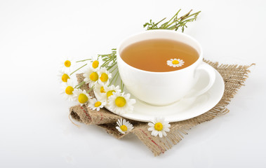 Fototapeta na wymiar Cup of tea and chamomiles