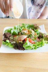 Droping salad cream to salad of shrimp,  crab meat, lettuce, aqu