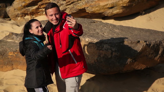 Selfie - Happy couple taking self portrait photo hiking. Two friends or lovers on hike smiling at camera outdoors.