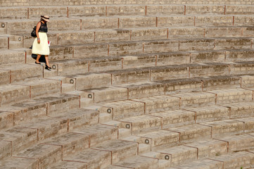 Lady walking down  steps at large theatre in Pompeii, Italy
