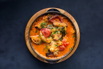 Mix steamed vegetables in a pan on dark table
