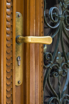 Weathered handle made of brass on wooden door