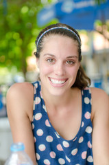 beautiful smiling girl looking at you against spring green bokeh