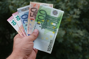 Man holds in his hand several euro banknotes