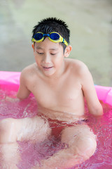 happy asian little boy playing in the pool