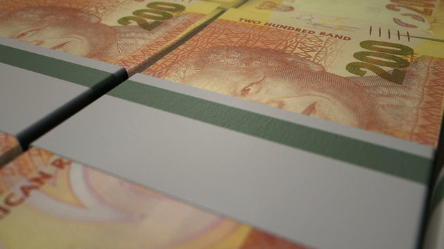 A macro closeup pan over a uniformly laid out collection of bundled wads of south african rand notes