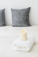 Cozy look, candle on white towel in living room.