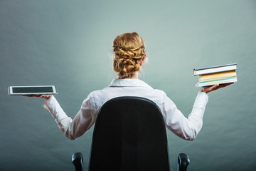 Woman holding traditional book and e-book reader