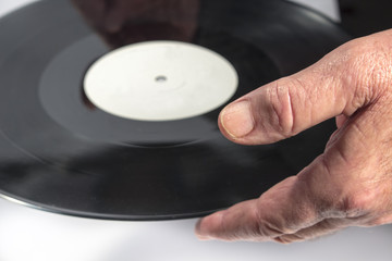 Close.up of the hand of a man while he is holding a vinyl record