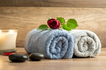 Obraz na płótnie Canvas Romantic arrangement of two rolled towels with a beautiful red r