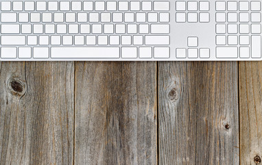 Computer keyboard on rustic wooden desktop