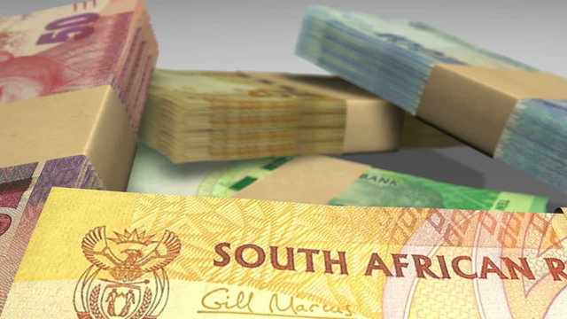 An extreme closeup pan of variously placed bundled wads of south african rand banknotes on a dark background