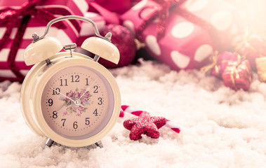 Vintage alarm clock on snow on christmas presents 