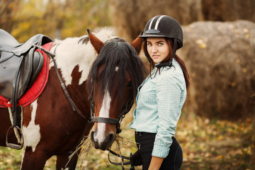Young woman on countryside with horse for riding
