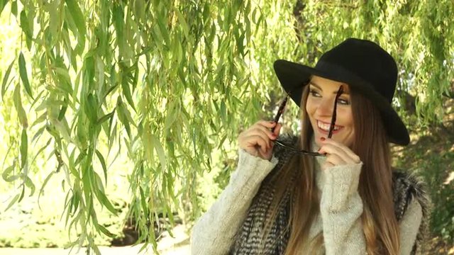 Woman outdoor. Fashion autumn girl relaxing in park 4K