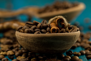 coffee beans in a spoon on blue wooden background