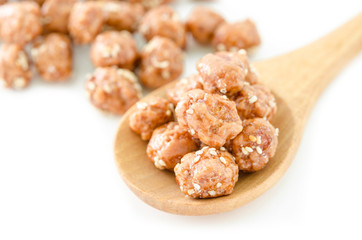 Honey roasted coated peanuts and white sesame seeds in wooden sp