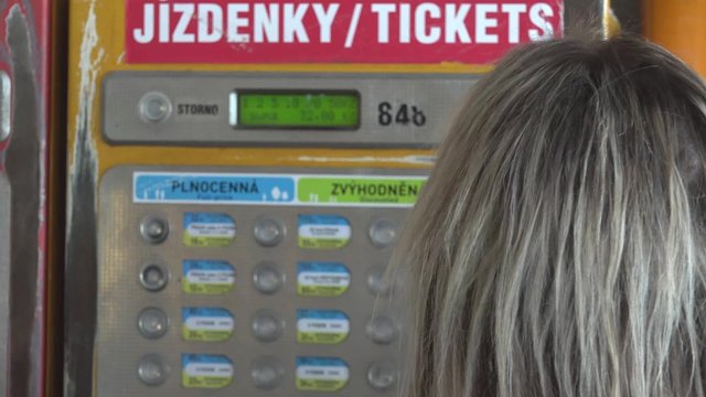 young attractive blonde woman buys a ticket for public transport - closeup