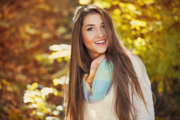 Excited happy woman smiling joyful and blissful holding autumn leaves outside in colorful fall forest