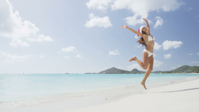 Christmas vacation travel woman jumping on beach