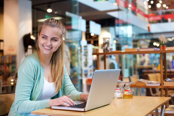 Smiling student sitting with laptop in class