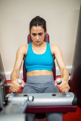 Woman using weights machine