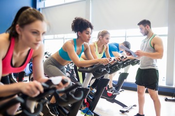 Fit people in a spin class - obrazy, fototapety, plakaty