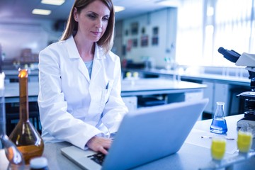 Scientist working with a laptop in laboratory - Powered by Adobe