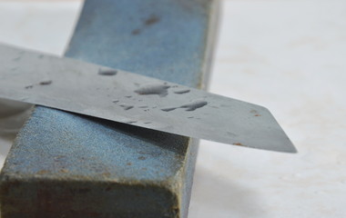 kitchen knife blade on grindstone