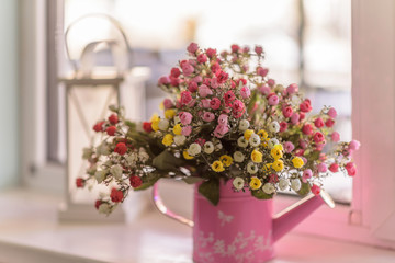 Watering can with pink and yellow flowers