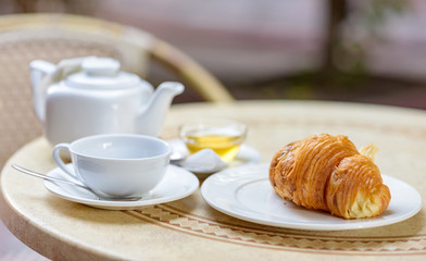 Fototapeta na wymiar French croissant on white plate on a restaurant table