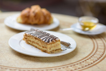 French croissant on white plate on a restaurant table