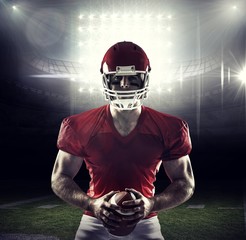 Composite image of american football player holding ball