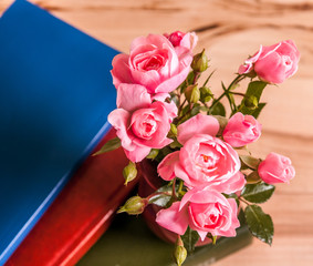 Pink roses in a vase on wooden background