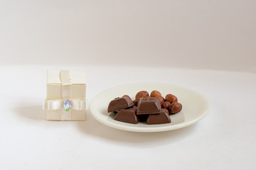 Chocolate and nuts in a white plate composition