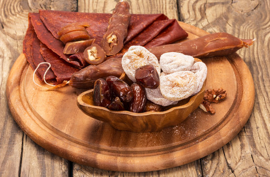 Oriental sweets churchkhela and nuts, on  wooden plate