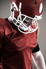 Composite image of american football player looking down