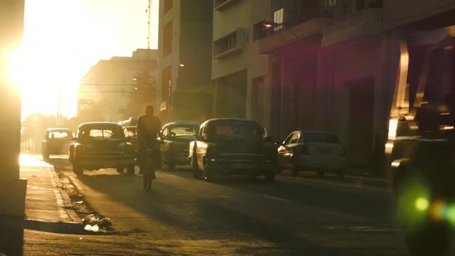Row of classic cars in traffic during the sunset glow in Havana