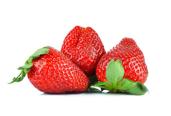 Three ripe strawberries with leaves on a white background