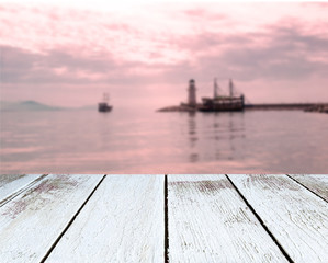 Lighthouse and ships, the sea, sunset, wooden plank in perspective