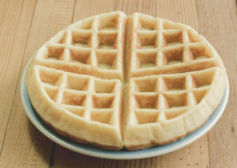 Full waffle with blue dish on the wooden background - Vintage Filter Effect