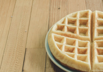 Full waffle with blue dish on the wooden background - Vintage Filter Effect